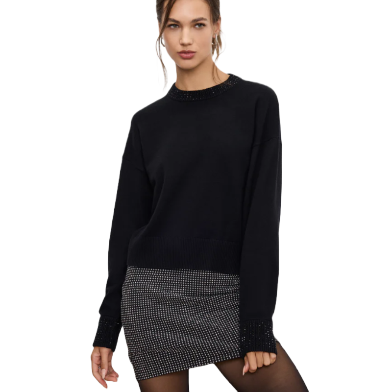 Black crewneck sweater featuring crystal embellishments on the neckline and cuffs, paired with a monochrome, checkered mini skirt and black tights.