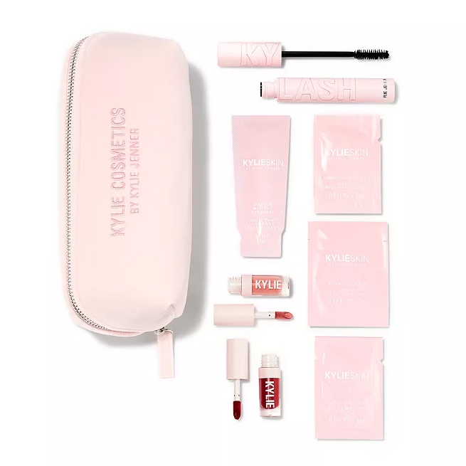 Kylie Cosmetics 8-piece set includes a pink cosmetic bag, mascara, a liquid lipstick, a lip gloss, a cleanser, and three skincare sachets, all in a soft pink color scheme.