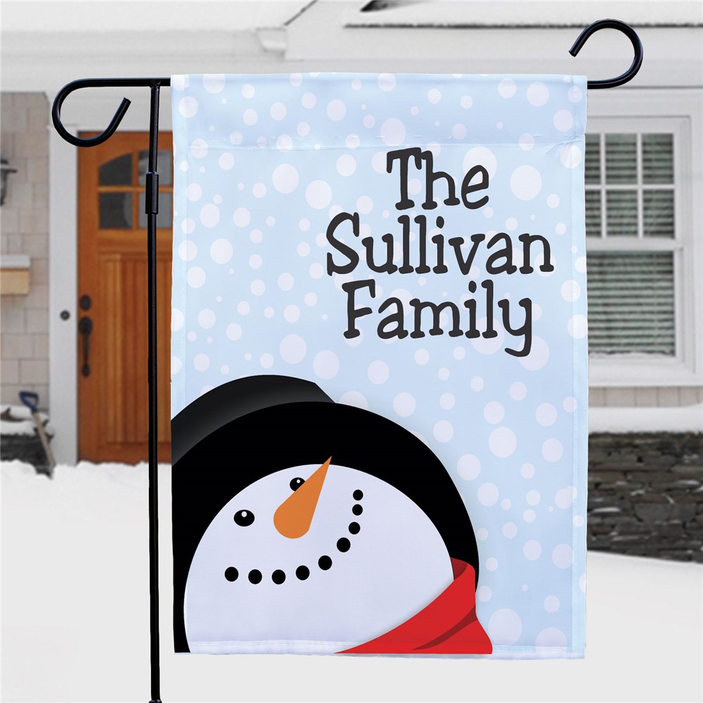 A personalized garden flag features a snowman design with a light blue, snowflake background and the text \“The Sullivan Family.\“