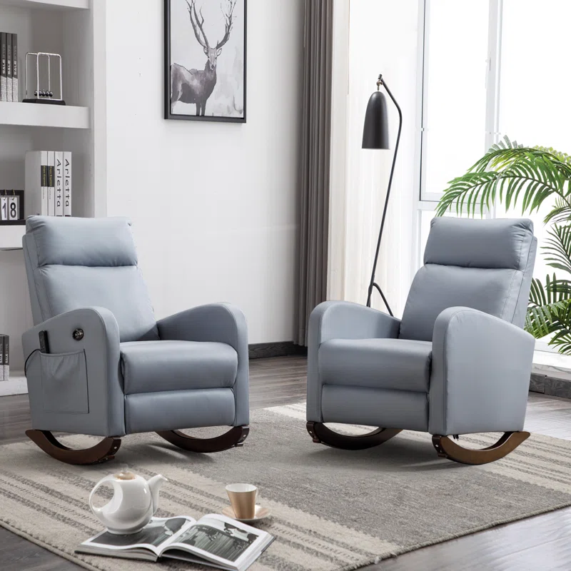 A 2-piece set of light gray massage rocker recliners on wooden bases, featuring side storage pockets. They are placed on a patterned rug in a modern living room with a floor lamp, potted plant, and a small table with a teapot and cup.