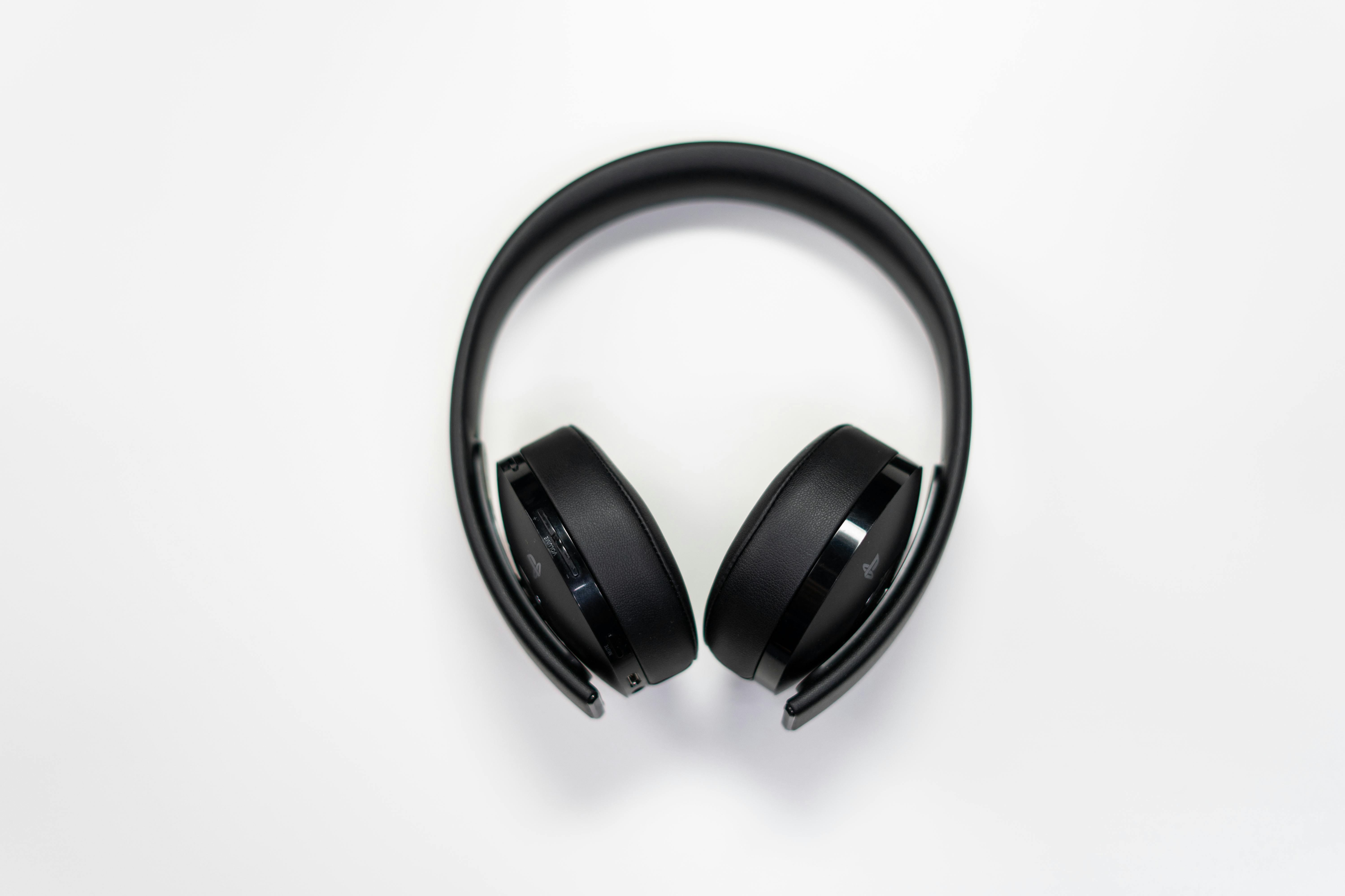 A pair of black over-ear wireless headphones with control buttons on the side.