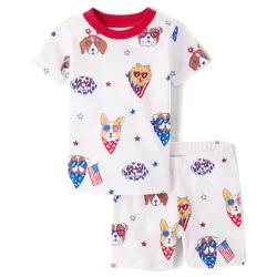 A short-sleeved toddler pajama set featuring a shirt and shorts with patriotic dog and cat faces wearing bandanas and star-themed sunglasses in red, white, and blue colors.