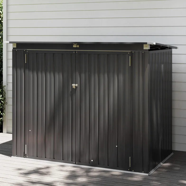 A compact, dark gray metal storage shed with a sloped roof and double doors secured by a lock, positioned on a wooden deck beside light-colored siding.
