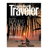 Cover of Conde Nast Traveler November 2025 issue, featuring the 2025 Readers' Choice Awards and articles on autumn in Japan, Sardinia's spirit, and Kilimanjaro adventures. Scenic sunset with sailboats and palm fronds in the background.