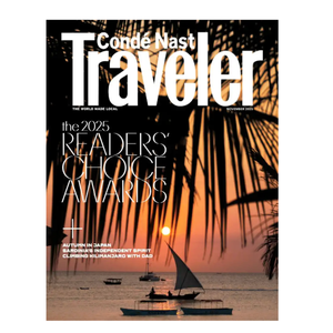 Cover of Conde Nast Traveler November 2025 issue, featuring the 2025 Readers' Choice Awards and articles on autumn in Japan, Sardinia's spirit, and Kilimanjaro adventures. Scenic sunset with sailboats and palm fronds in the background.