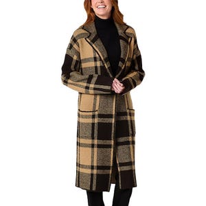 A woman is wearing a knee-length coatigan with a wide lapel featuring a plaid pattern in shades of brown, black, and beige.