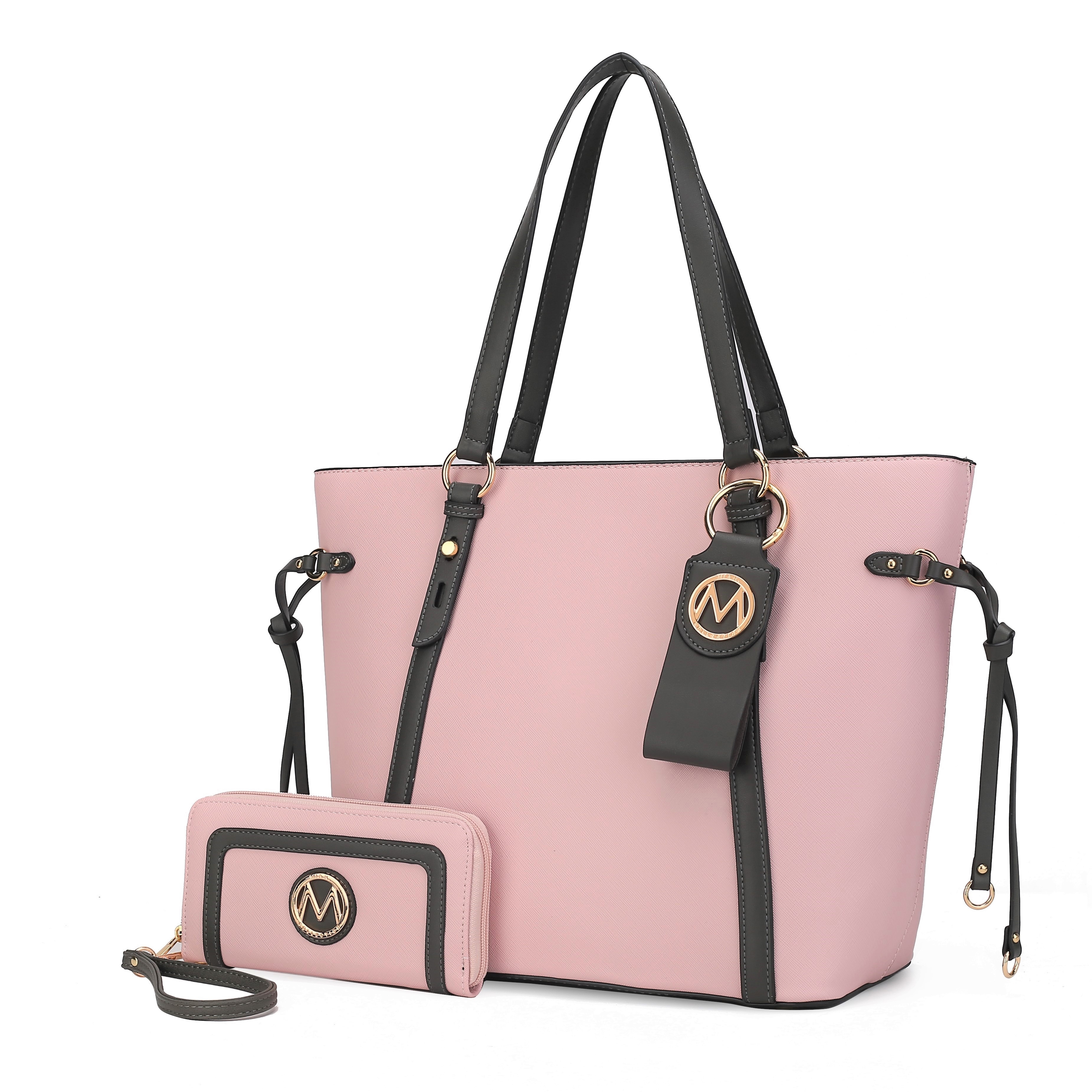 A pink and black tote bag with dual handles and gold accents, accompanied by a matching pink wallet with a wrist strap. Both feature a circular emblem with an \“M\“ design.