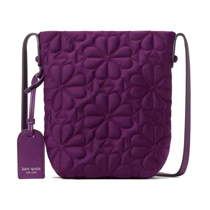 Purple crossbody bag with floral quilting and a matching luggage tag displaying a brand logo.