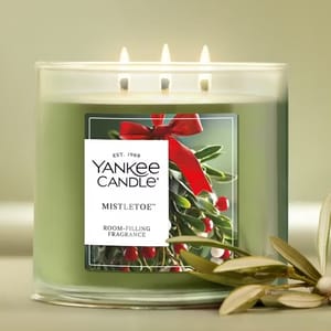 Yankee Candle Mistletoe scented candle with three wicks and green wax, featuring a label with mistletoe imagery and the text \“room-filling fragrance.\“