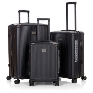 A set of three black hardshell luggage pieces with vertical ridges, extendable handles, and four wheels each.