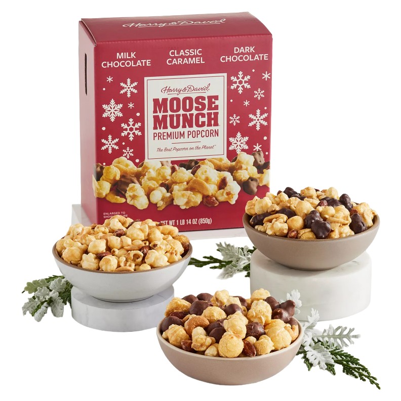 Harry & David Moose Munch Premium Popcorn variety pack with milk chocolate, classic caramel, and dark chocolate flavors, displayed in bowls with holiday-themed packaging.