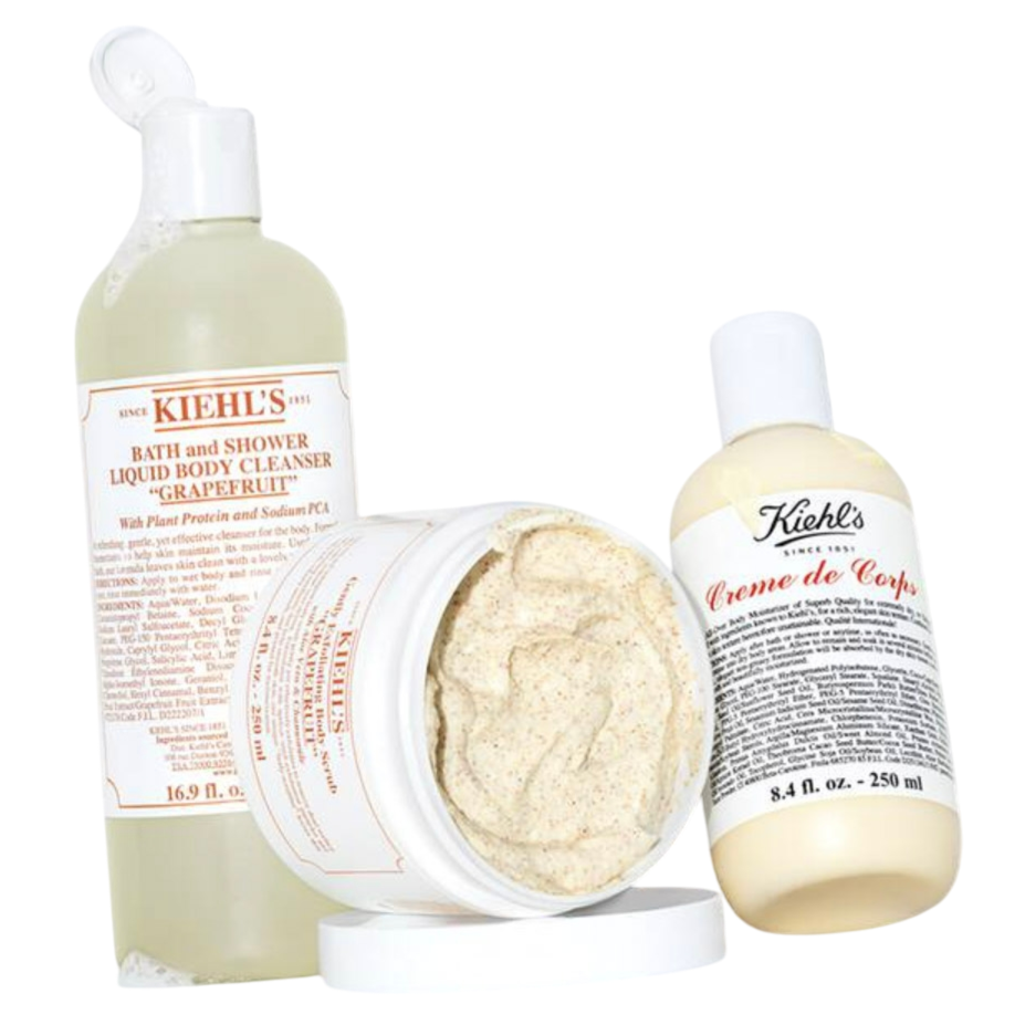 Three Kiehl's products: a 16.9 fl. oz. Bath and Shower Liquid Body Cleanser in \“Grapefruit,\“ a body scrub in a jar, and an 8.4 fl. oz. bottle of Creme de Corps body lotion.