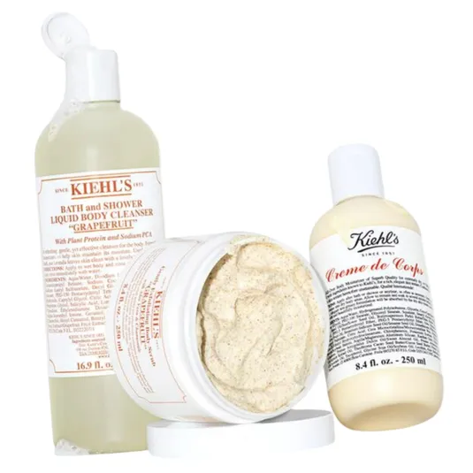 Three Kiehl's products: a 16.9 fl. oz. Bath and Shower Liquid Body Cleanser in \“Grapefruit,\“ a body scrub in a jar, and an 8.4 fl. oz. bottle of Creme de Corps body lotion.