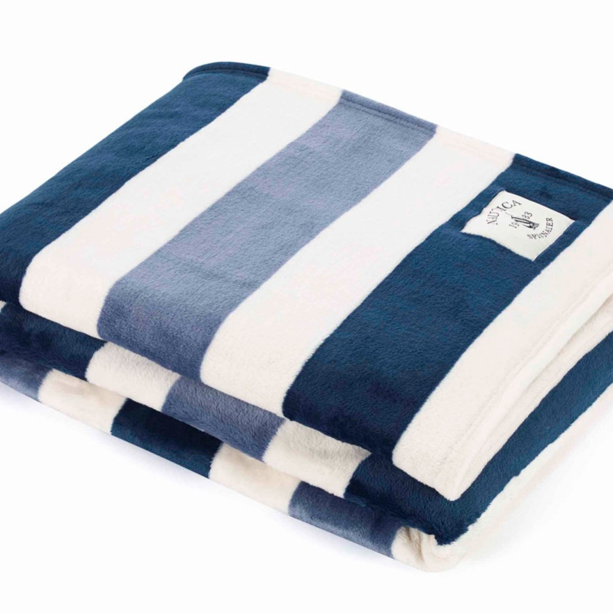 A folded blanket featuring wide, horizontal stripes in navy blue, light blue, and white with a small branded label.