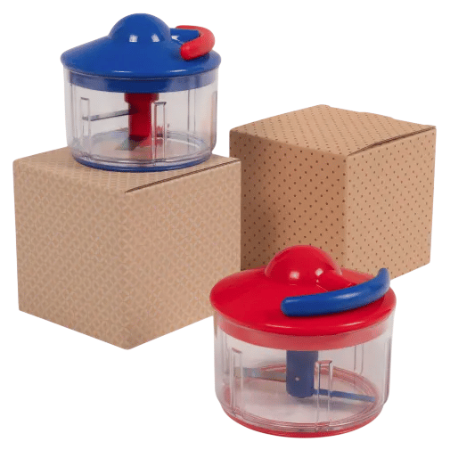 Two manual food choppers with red and blue lids are displayed on and beside brown patterned boxes.