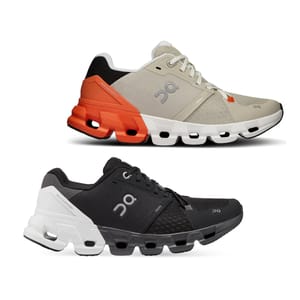 Two pairs of On Cloudmonster running shoes, one in beige and orange, the other in black and white.