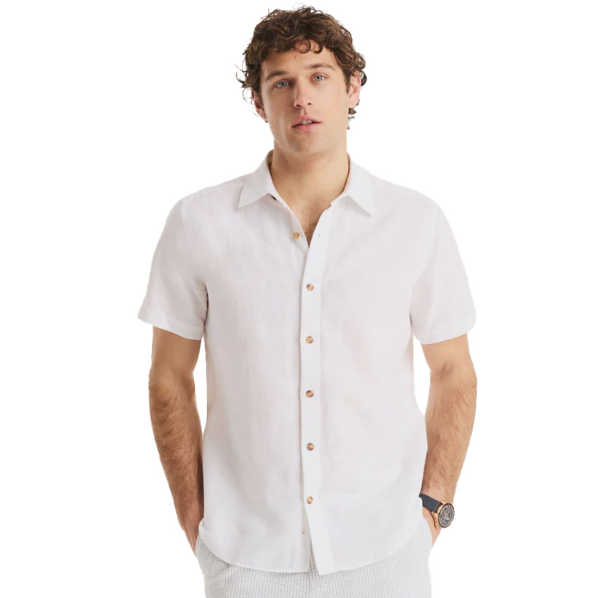 A man models a short-sleeve white linen button-up shirt with brown buttons and a classic collar, paired with light, textured pants, suitable for casual or semi-formal occasions.