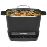 A PowerXL multi-cooker with a digital control panel, featuring a clear lid and handles, filled with a seafood and rice dish.