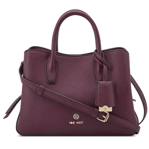 A purple Nine West handbag with top handles, a detachable shoulder strap, and a gold-tone logo accent, featuring a structured design and a luggage tag detail.