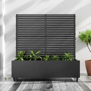 A sleek, black planter box with integrated horizontal slat trellis, housing several small green plants. The box is on wheels for easy mobility, placed on a wooden floor, making it suitable for indoor or outdoor use.