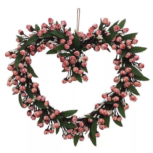 Heart-shaped wreath adorned with pink rosebuds and green leaves, featuring a central cluster for added decoration.