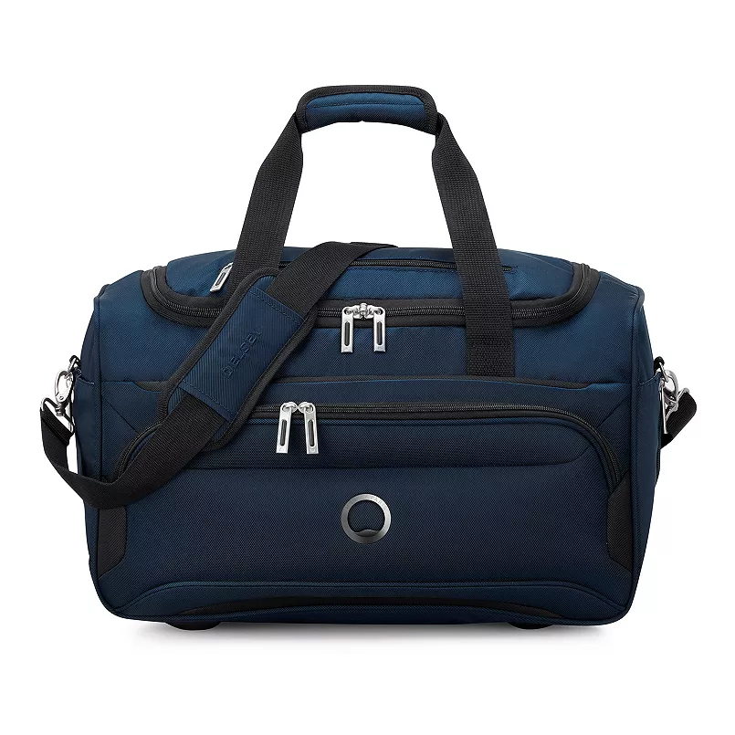 A navy blue Delsey Paris duffle bag with black accents, featuring dual handles, an adjustable shoulder strap, and multiple zippered compartments for storage.