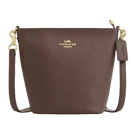 Brown Coach bucket bag with gold hardware and detachable strap, featuring the Coach logo on the front and a leather tag.