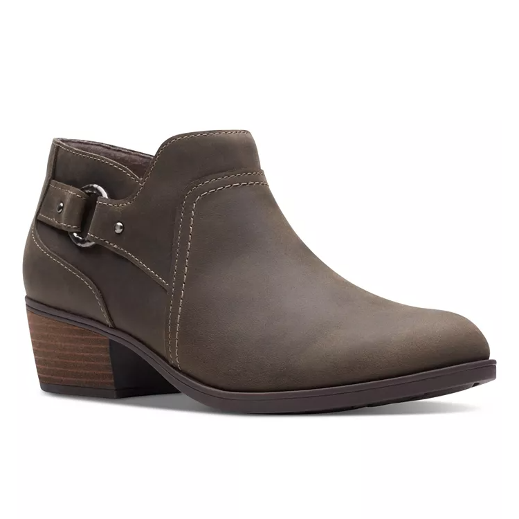Brown leather ankle booties with a low stacked heel, decorative side buckle, and visible stitching.