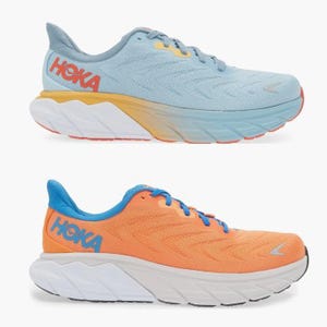 Two pairs of Hoka running shoes, one in light blue and yellow, the other in orange and white.