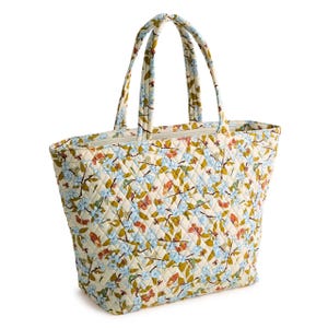 A quilted tote bag featuring a multicolored floral pattern on a light background, with two matching handles.
