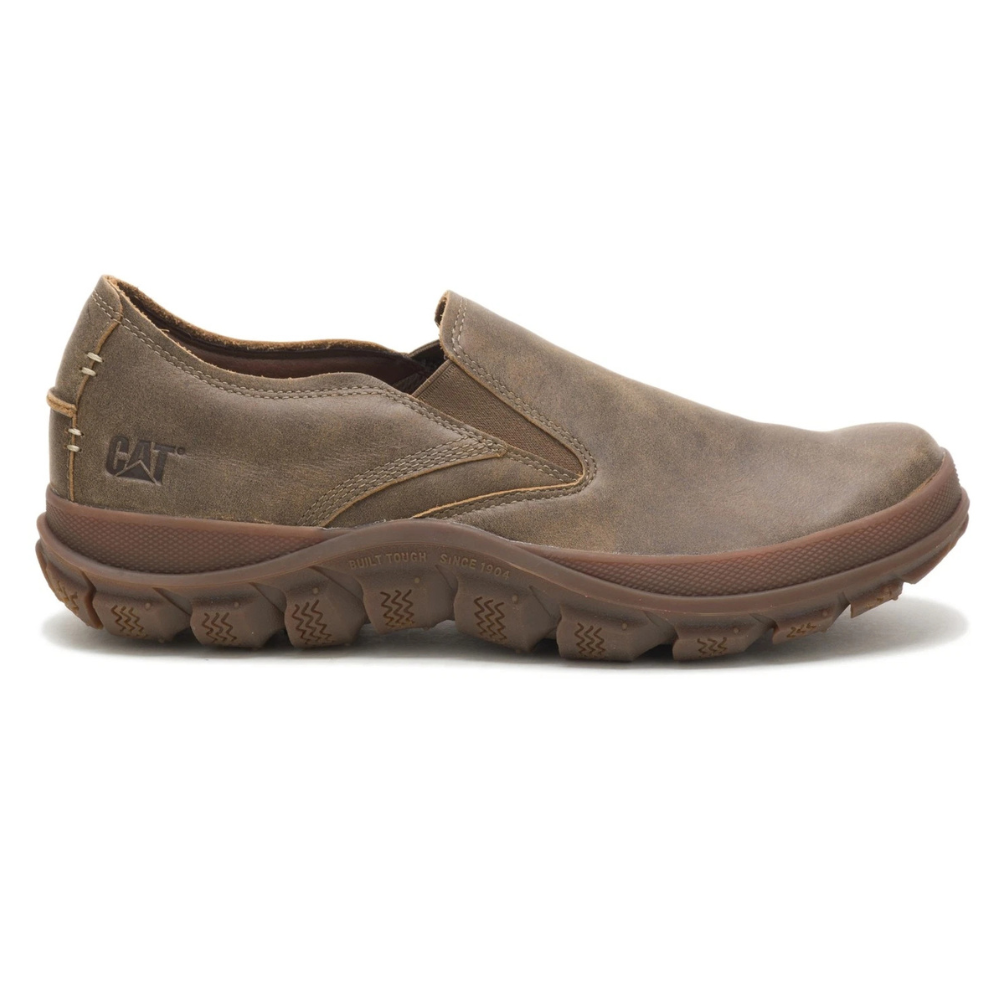 Brown slip-on shoe with rugged sole and \“CAT\“ logo, designed for durability and comfort.