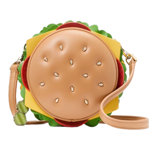 A handbag designed to resemble a hamburger, featuring a circular tan bun with sesame seed details, layers of colorful faux lettuce, tomato, and cheese, and a detachable strap.