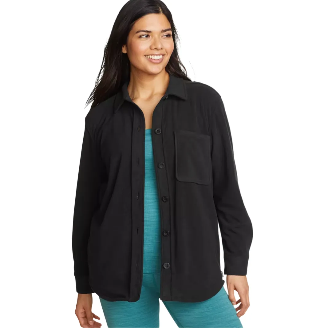 A woman is wearing a black button-up shirt with a chest pocket over a turquoise top and bottoms.