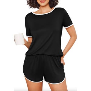 Black short-sleeve pajamas with white trim and pockets, featuring a relaxed fit and matching shorts.