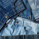 Various pairs of OshKosh denim jeans are laid out, showcasing different shades of blue.