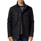 A man is wearing a dark grey jacket with snap-button pockets over a blue textured sweater, paired with blue jeans.