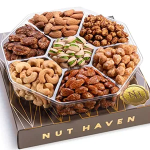 A round, divided platter contains various nuts, including almonds, cashews, pistachios, and candied nuts. The platter is labeled \“Nut Haven\“ and rests on a decorative box.