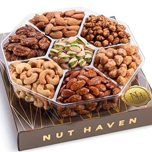 A round, divided platter contains various nuts, including almonds, cashews, pistachios, and candied nuts. The platter is labeled \“Nut Haven\“ and rests on a decorative box.