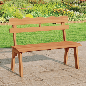 A wooden garden bench with a scalloped backrest is placed on a stone patio, surrounded by lush greenery and vibrant flowers.