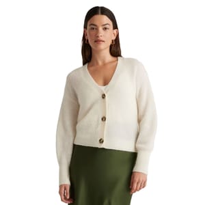 A white alpaca cropped cardigan featuring a V-neck, long sleeves, and three large brown buttons down the front.