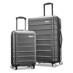 Two hard-shell suitcases with telescopic handles and four spinner wheels, featuring a ribbed design. They are gray and come in different sizes, suitable for travel.