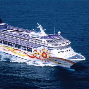 A cruise ship sailing on the ocean, with colorful sun-themed artwork on its side and the name \“Norwegian Sun\“ visible on the hull.