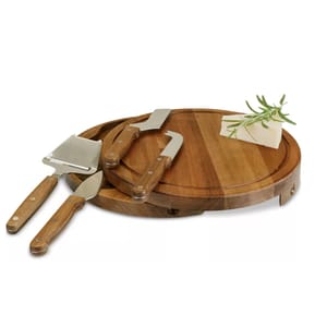 A round wooden cheese board with a sliding drawer containing three utensils: a cheese slicer, a spreader, and a pronged knife, all with wooden handles. The board displays a wedge of cheese garnished with rosemary.