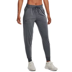 Gray joggers with an elastic waistband and ankle cuffs, featuring a drawstring and small logo on the left thigh. Paired with white athletic shoes.