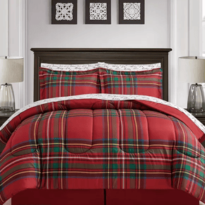 A red and green plaid comforter set with two matching pillow shams on a bed, complemented by decorative framed art and a table lamp.