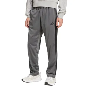 Gray athletic track pants with a three-stripe design and brand logo, paired with white sneakers and a gray sweatshirt.