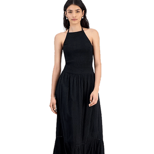 A woman wearing a black halter-neck midi dress with a fitted bodice and flared skirt.