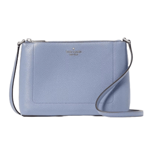 A light blue leather Kate Spade crossbody bag features a pebbled texture, a slim design, and a long adjustable strap, complemented by a small printed logo on the front.