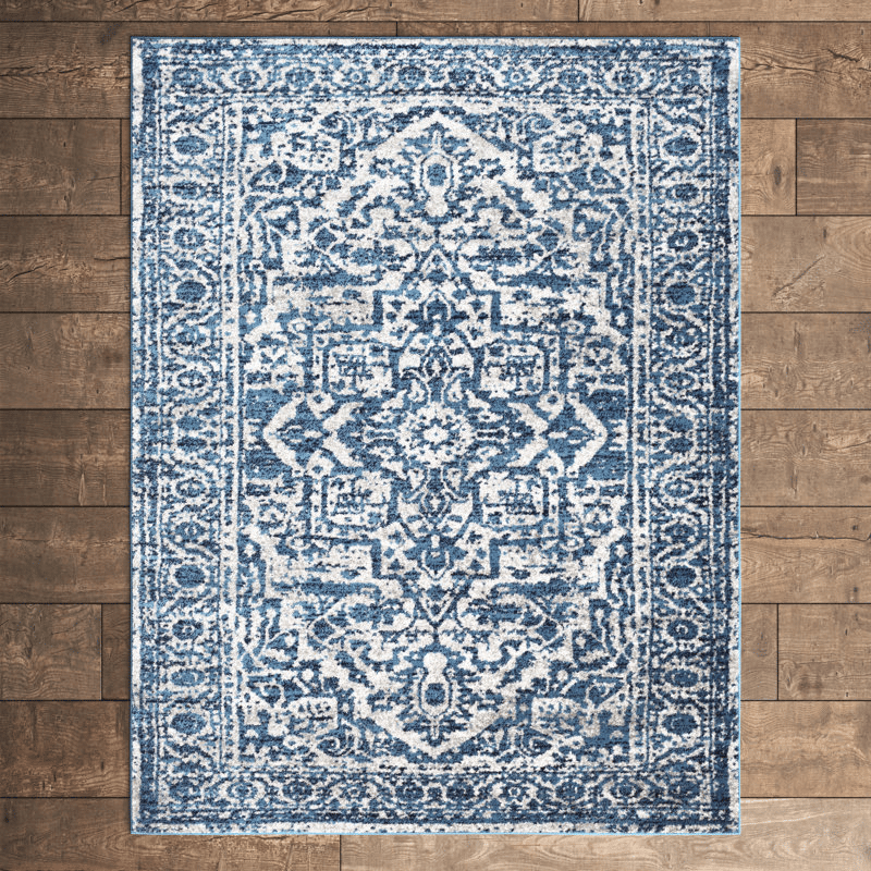 A blue and white area rug with a traditional, intricate pattern lies on a hardwood floor.