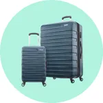 A pair of blue hard-shell suitcases with grooved designs and four swivel wheels, featuring telescopic handles in a minimalist turquoise background.